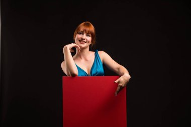 Sunu gösterilen, afiş üzerinde işaret eden genç neşeli kadın