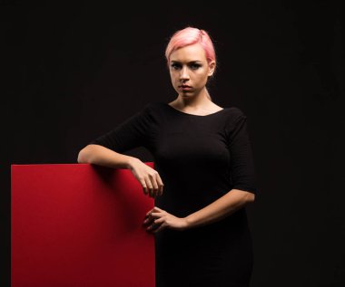 Sunu gösterilen, afiş üzerinde işaret eden genç ciddi kadın