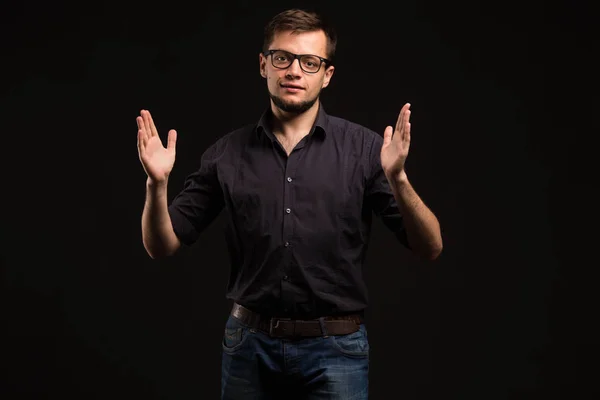 Junger fröhlicher Mann zeigt sich an den Händen — Stockfoto