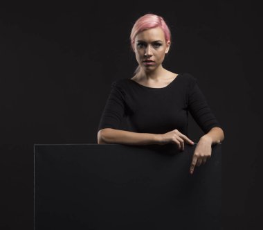 Sunu gösterilen, afiş üzerinde işaret eden genç seksi kadın