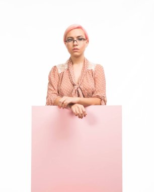 Sunu gösterilen, afiş üzerinde işaret eden genç üzgün kadın