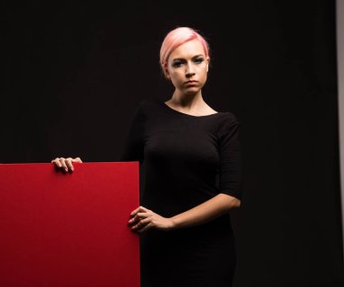 Sunu gösterilen, afiş üzerinde işaret eden genç ciddi kadın