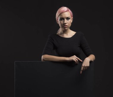 Sunu gösterilen, afiş üzerinde işaret eden genç seksi kadın