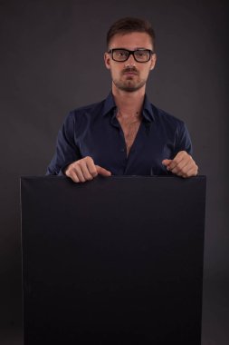 Sunu gösterilen, afiş üzerinde işaret eden genç seksi adam