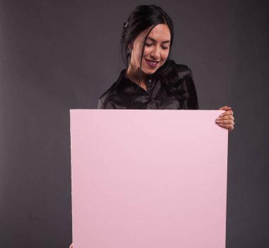 Sunu gösterilen, afiş üzerinde işaret eden genç dalgın kadın