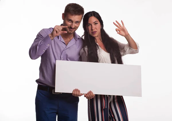 Jovem casal feliz mostrando apresentação apontando cartaz — Fotografia de Stock