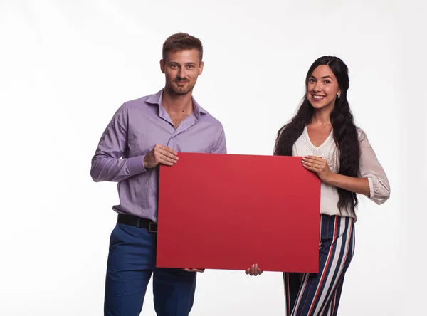 Jovem casal feliz mostrando apresentação apontando cartaz — Fotografia de Stock