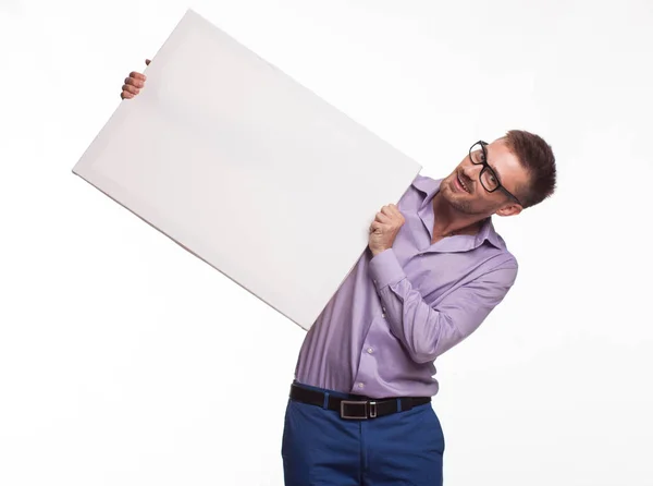 Jovem jocular mostrando apresentação, apontando em cartaz — Fotografia de Stock