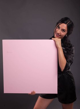 Sunu gösterilen, afiş üzerinde işaret eden genç kendine güvenen kadın