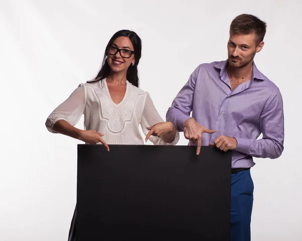 Ung självsäker par visar presentationen pekar plakat — Stockfoto