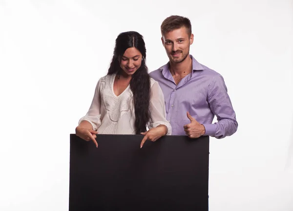 Молодая счастливая пара показывает презентацию, указывая на плакат — стоковое фото