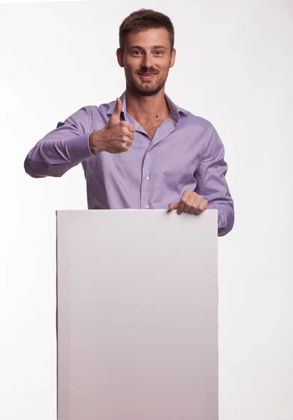 Jovem homem feliz mostrando apresentação, apontando no cartaz — Fotografia de Stock