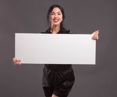 Sunu gösterilen, afiş üzerinde işaret eden genç kendine güvenen kadın