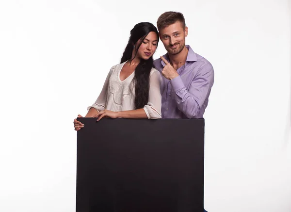Giovane coppia felice mostrando presentazione puntando cartello — Foto Stock