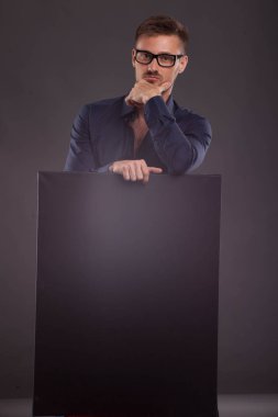 Sunu gösterilen, afiş üzerinde işaret eden genç seksi adam