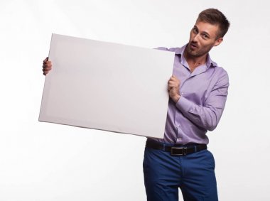 Genç sunu gösterilen, afiş üzerinde işaret eden adam şaşırttı