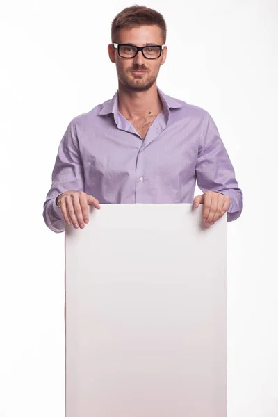 Молодий впевнений чоловік показує презентацію, вказуючи на плакат — стокове фото