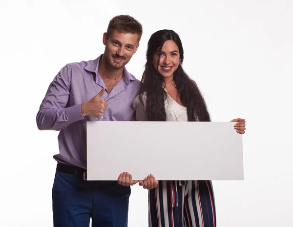 Joven feliz pareja mostrando presentación señalando cartel — Foto de Stock