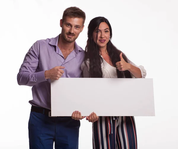 Joven feliz pareja mostrando presentación señalando cartel — Foto de Stock