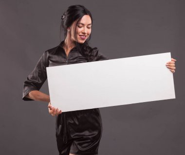 Sunu gösterilen, afiş üzerinde işaret eden genç seksi kadın