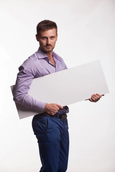 Jovem homem confiante mostrando apresentação, apontando no cartaz — Fotografia de Stock