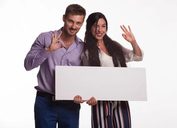 Joven feliz pareja mostrando presentación señalando cartel — Foto de Stock