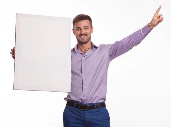 Giovane uomo felice mostra presentazione, puntando sul cartello — Foto Stock