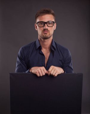 Sunu gösterilen, afiş üzerinde işaret eden genç seksi adam