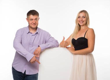 Sunu işaret gösterilen genç mutlu çift tasarlamak.