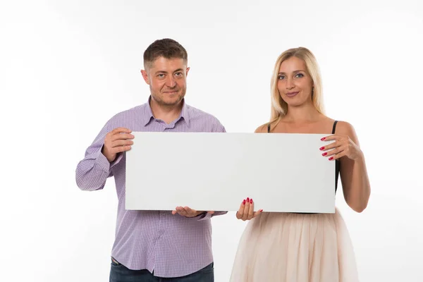 Giovane coppia felice mostrando presentazione puntando cartello . — Foto Stock