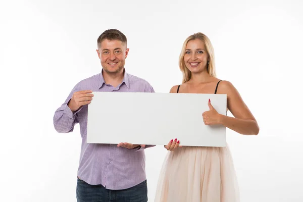 Joven feliz pareja mostrando presentación señalando cartel . — Foto de Stock