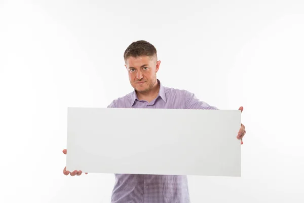 Jovem homem confiante mostrando apresentação, apontando no cartaz . — Fotografia de Stock