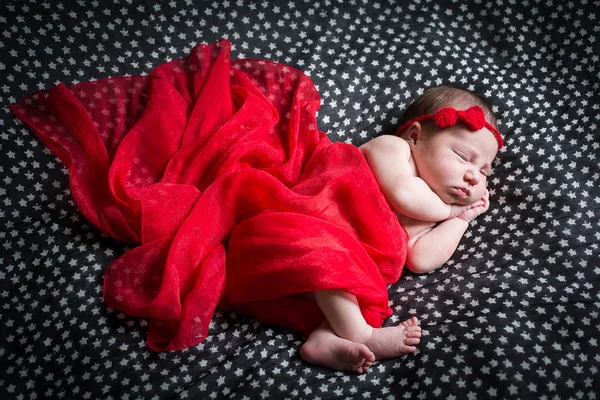 Sover nyfödda i röd klänning. — Stockfoto