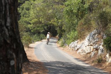 Ormanın içinden dolambaçlı yol üzerinde kadın motorcu