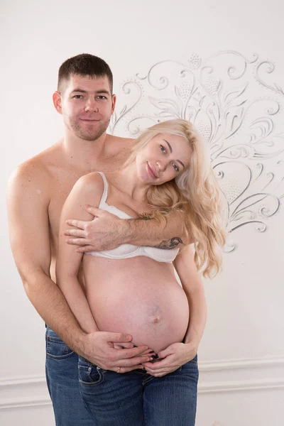 Vackra gravida par i kärlek på bakgrunden. — Stockfoto