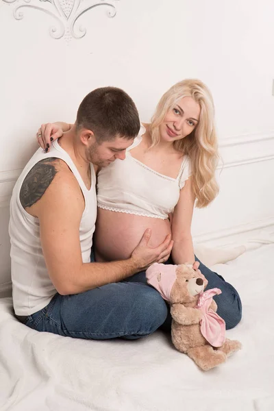 Schöne schwangere Paar in der Liebe auf dem Hintergrund. — Stockfoto