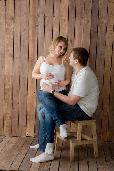 Schöne schwangere Paar in der Liebe auf dem Hintergrund. — Stockfoto