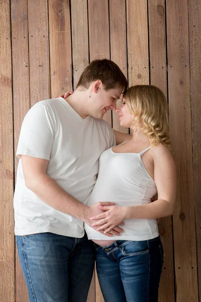 Schöne schwangere Paar in der Liebe auf dem Hintergrund. — Stockfoto