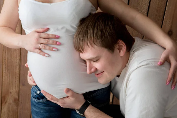 Vackra gravida par i kärlek på bakgrunden. — Stockfoto