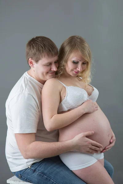 Casal grávida bonita no amor no fundo . — Fotografia de Stock