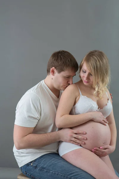 Hermosa pareja embarazada enamorada en el fondo . — Foto de Stock