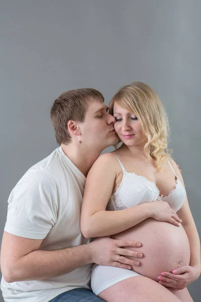 Casal grávida bonita no amor no fundo . — Fotografia de Stock