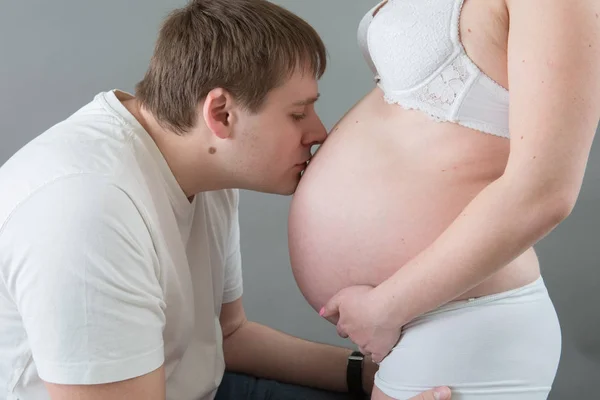 Casal grávida bonita no amor no fundo . — Fotografia de Stock