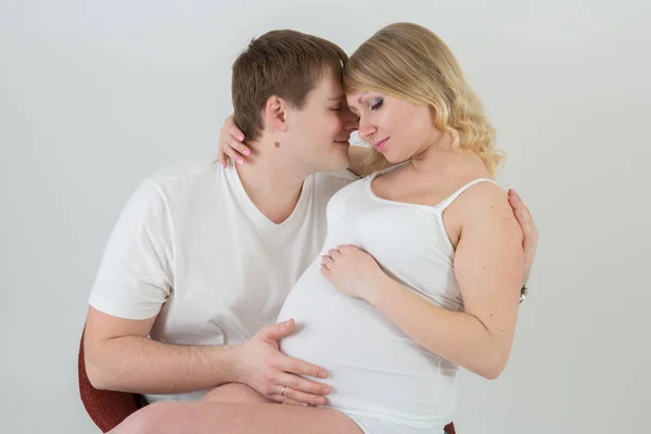 Hermosa pareja embarazada enamorada en el fondo . —  Fotos de Stock
