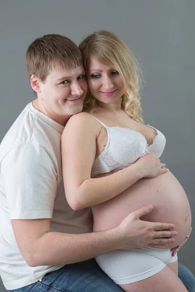 Casal grávida bonita no amor no fundo . — Fotografia de Stock