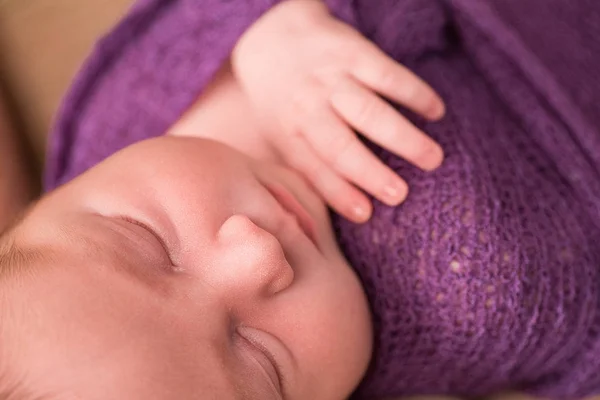 Sovande nyfödd flicka i en violett sticka Babyfilt. — Stockfoto