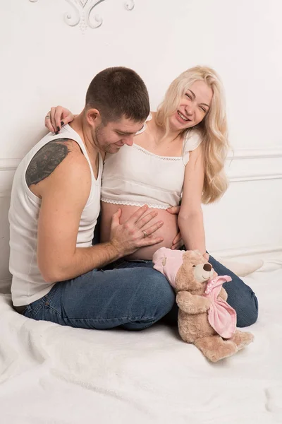 Vackra gravida par i kärlek på bakgrunden. — Stockfoto