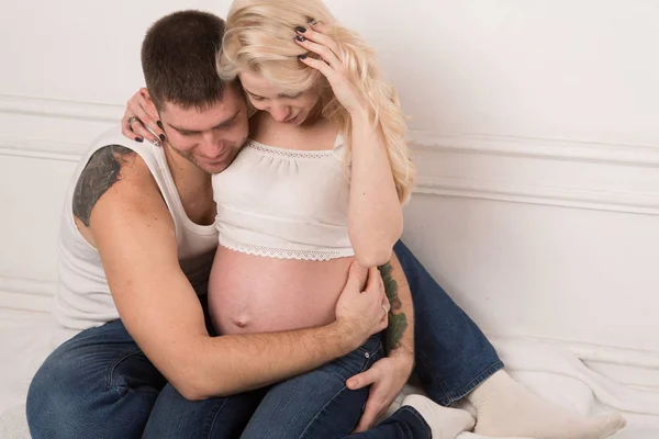 Hermosa pareja embarazada enamorada en el fondo . —  Fotos de Stock