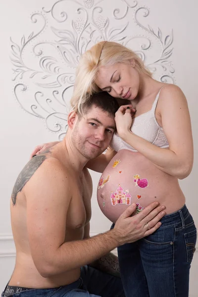 Vackra gravida par i kärlek på bakgrunden. — Stockfoto