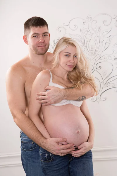 Casal grávida bonita no amor no fundo . — Fotografia de Stock